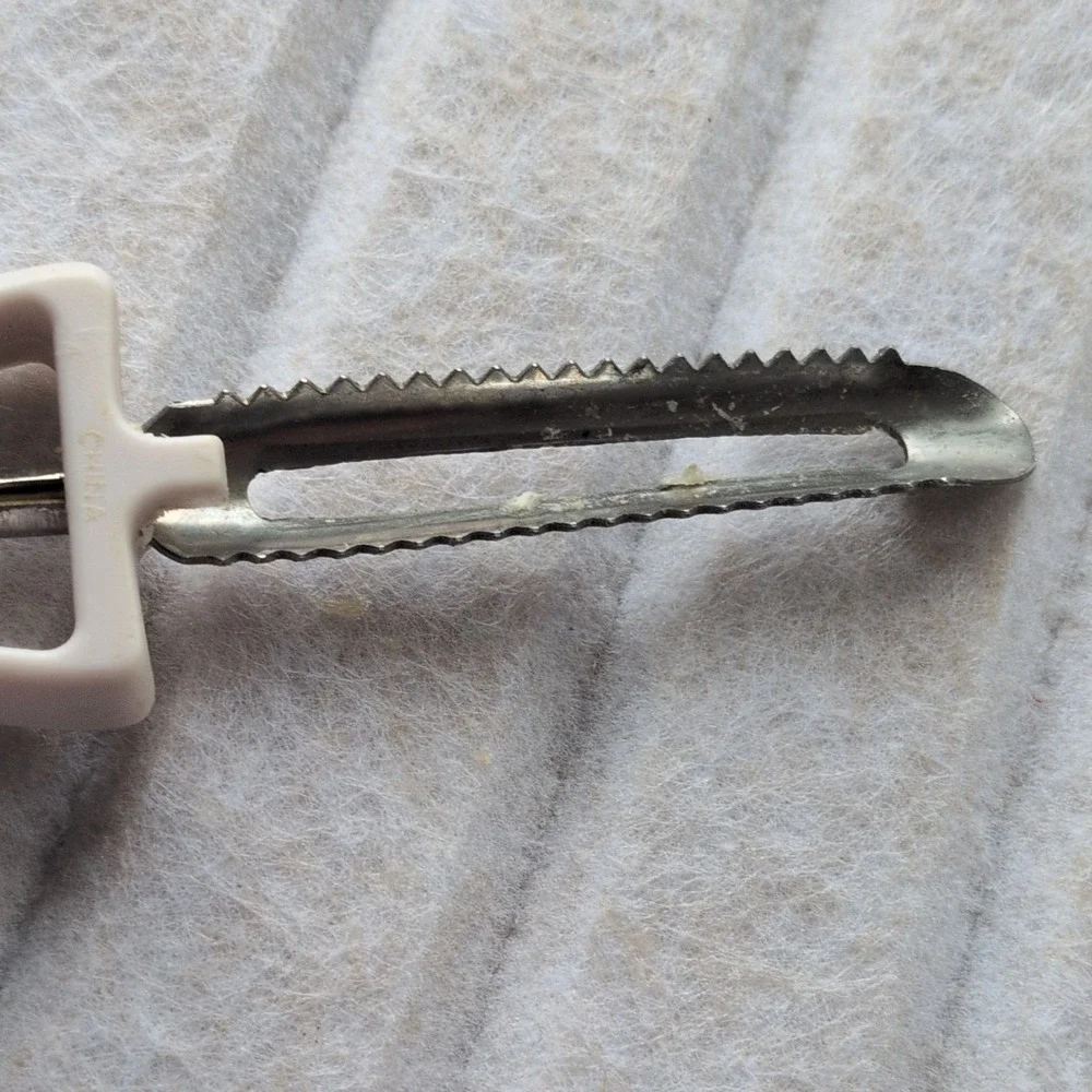 Manual Serrated Vegetable Peeler with‎ White Plastic Handle and Metal Blade